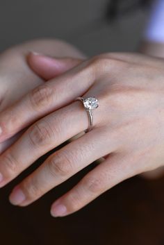 a woman's hand with a diamond ring on it