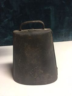 an old metal container sitting on top of a white table