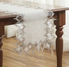 a table with a white doily on top of it and a wooden table in the background