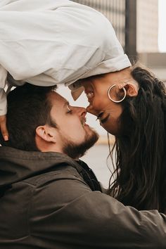 a man and woman kissing each other while holding on to one another's head