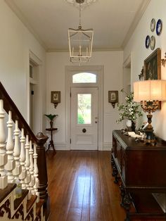 an entryway with wooden floors and white walls, two lamps on either side of the door