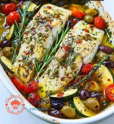 fish with olives, tomatoes and peppers in a white dish