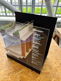 an architectural model of a building on top of a wooden table