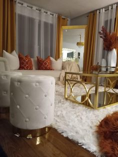 a living room filled with white furniture and gold accents