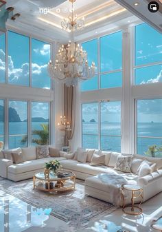 a living room filled with lots of furniture and large windows overlooking the ocean at night