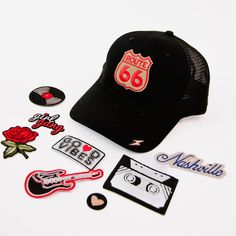 a hat, stickers and other items are laid out on a white table top