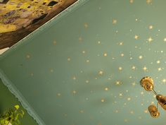 the ceiling has gold stars on it and is painted green with gold foiling,