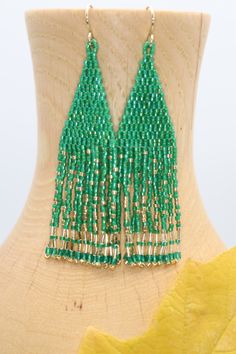 Handmade artisan boho chandelier earrings in the most gorgeous shades of emerald green and gold with gently swaying fringe. Each tiny bead is selected and hand sewn into place, one at a time with a needle and thread. No plastics, no glue, no looms - completely hand stitched with strong nylon thread.Ear wires are gold filled.Lightweight and comfortable, these earrings make a great gift or stocking stuffer for that special woman or a treat for yourself. All our items ship boxed and ready to gift. Green Beaded Fringe Tassel Earrings Gift, Green Beaded Fringe Earrings For Party, Green Beaded Fringe Earrings For Gift, Green Fringed Beaded Earrings, Adjustable Green Fringe Beaded Earrings, Boho Chandelier, Fringe Earrings, Handmade Artisan, Needle And Thread