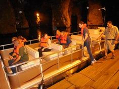 several people on a boat at night with one person standing and the other sitting down