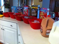 red bowls filled with cereal sit on the kitchen counter next to milk and other food