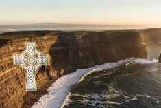 an aerial view of the ocean and cliffs with a cross on it