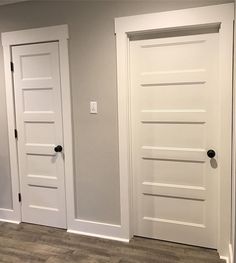 two white doors in the middle of a room