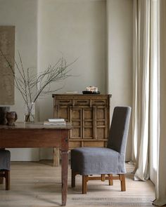 a dining room table with two chairs and a vase on it