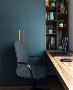 an office chair sitting in front of a desk with bookshelves and plants on it