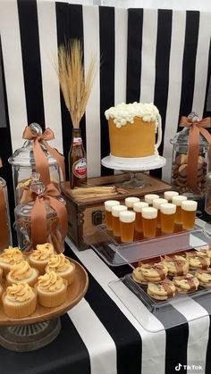 an assortment of desserts and pastries displayed on a table with black and white stripes