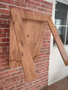 a wooden sculpture on the side of a brick building with a window in it's center