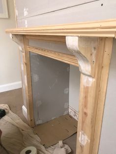 an unfinished fireplace with some tape on the mantle and toilet paper in front of it