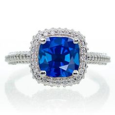 a blue cushion cut ring with diamonds around it