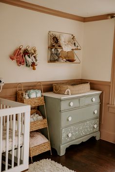 a baby's room with a dresser, crib and other items on the wall