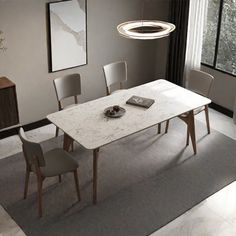 a dining room table with chairs and a book on the rug in front of it