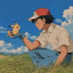 a man kneeling in the grass with a pokemon pikachu on his hand and a sky background