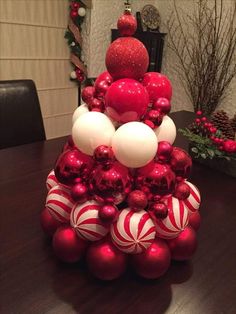 a christmas tree made out of red and white ornaments on top of a wooden table