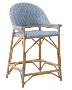 an upholstered chair with blue fabric and wickers on the back, in front of a white background