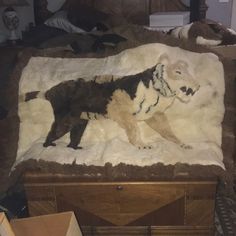 a dog is laying on top of a bed covered in blankets and fur, with other items scattered around it