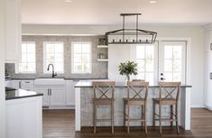 a kitchen with two bar stools next to an island