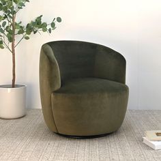 a green chair sitting next to a potted plant on top of a carpeted floor