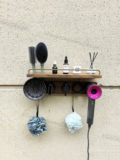 a hair dryer sitting on top of a wooden shelf next to two blow dryers