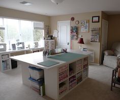 a sewing room with lots of crafting supplies on the desk and shelves in front of the window