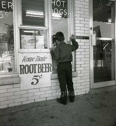 a man standing in front of a store window with his hand up to the window