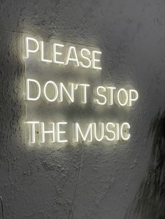 a neon sign that says, please don't stop the music on a wall