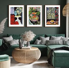 three paintings hang on the wall above a green couch and coffee table in a living room