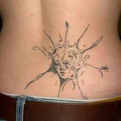 a woman's back with a tattoo design on her lower body and the bottom part of her stomach