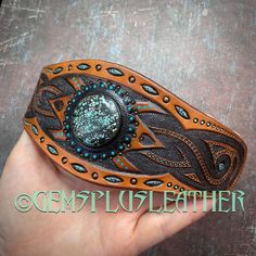 "\"The wheel of time\" is a hand tooled and hand painted leather cuff bracelet with natural turquoise gemstone. It would become a nice accessory for a modern Valkyrie. The item is almost ready to ship and will be delivered to you by registered airmail service once finalized. It just misses a snap button, which will be added in accordance with buyer's preferences. The size of the cuff can be finalized to fit a wrist size up to 7 1/4\" (~19 cm). Let me know the chosen size upon checkout. The cuff Brown Bohemian Leather Bracelet With Concho, Handmade Southwestern Adjustable Leather Bracelet, Southwestern Style Turquoise Leather Bracelet For Festivals, Artisan Hand-wrapped Leather Bracelet For Festivals, Artisan Hand Wrapped Leather Bracelet For Festivals, Bohemian Brown Cuff Bracelet With Patina, Bohemian Adjustable Bracelets With Concho, Bohemian Adjustable Concho Bracelets, Adjustable Bohemian Concho Bracelets