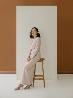 a woman sitting on top of a wooden stool