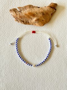 - Discover the unique charm of our adjustable bracelet, expertly handcrafted with navy Miyuki beads, striped Czech beads, and a single freshwater pearl that adds a touch of elegance. A vibrant red Miyuki bead provides a stunning contrast, making this piece perfect for accessorizing any outfit. 🌟 📏 Adjustable design to fit any wrist size comfortably. 🌊 Navy and white striped Czech beads create a classic nautical look. ❤️ Single red Miyuki bead adds a pop of color. 🔳 Features a solitary freshw Adjustable Beaded Bracelets With Letter Beads As Souvenir, Adjustable Braided Bracelet With Letter Beads, Casual Navy Bracelets For Gifts, Casual Navy Bracelet As A Gift, Adjustable Blue Evil Eye Bracelet With Sliding Knot, Blue Braided Bracelets With Colorful Beads For Gift, Adjustable Blue Friendship Bracelets With Letter Beads, Adjustable Blue Braided Bracelet With Colorful Beads, Adjustable Bohemian Beaded Bracelets As Souvenir