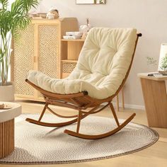 a living room with a rocking chair and potted plant