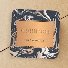 a square coaster with the words elizabeth parker in gold and blue marbled paper on it