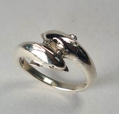 **Please note that we dispatch on Tuesdays unless special delivery express option is paid for** Sterling silver Dolphin crossover ring. Original design carved in wax then lost wax cast into solid sterling silver.  Handmde in London.  Available in ring sizes A-Z6. First class post included. Dolphin Ring, Crossover Ring, Lost Wax, Special Delivery, Ring Sizes, Sterling Silber, Dolphins, Handmade Silver, Original Design