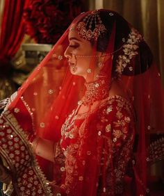 a woman in red and gold bridal outfit