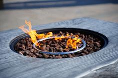 a bowl filled with food on top of a wooden table covered in fire pit material