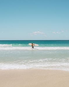 a person holding a surfboard in the water on a sunny day at the beach