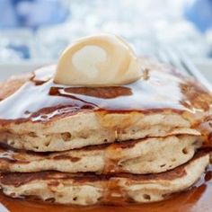 a stack of pancakes covered in syrup and butter