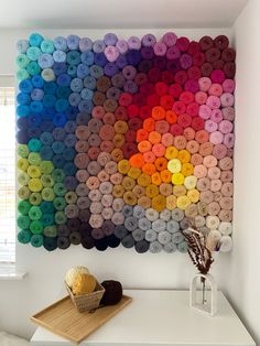 there is a large multicolored wall hanging on the wall next to a basket