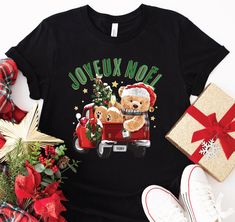 a black t - shirt with a teddy bear driving a red truck holding a christmas tree