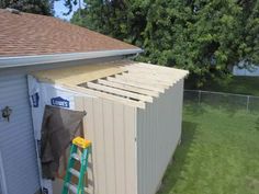 a small storage shed with a ladder leaning against it