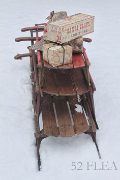 a wooden sled filled with lots of presents on top of it in the snow